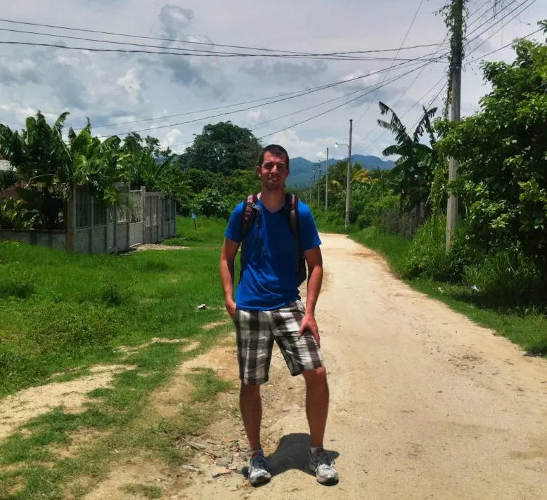 Keith Andrew standing on a rural road during his travels